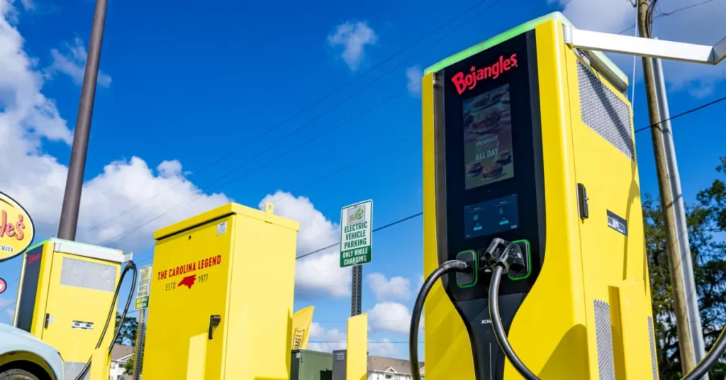 Estação de recarga rápida para carros elétricos em frente a um restaurante.
