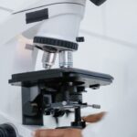 Pesquisador utilizando um microscópio em um laboratório de biologia.
