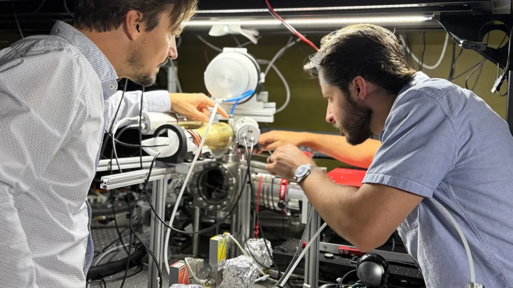 Cientistas realizando experimentos com folhas metálicas em laboratório.