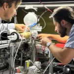 Cientistas realizando experimentos com folhas metálicas em laboratório.