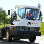 Trator de pátio elétrico Kalmar Ottawa T2 EV operando em um terminal de carga.